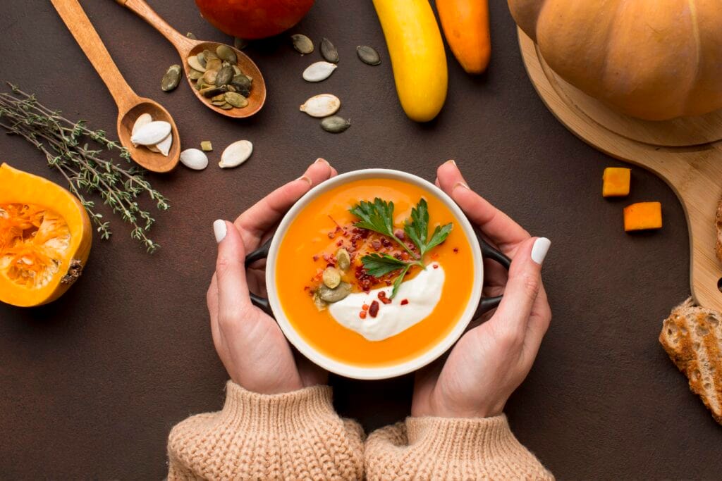 flat lay winter squash soup bowl held by hands